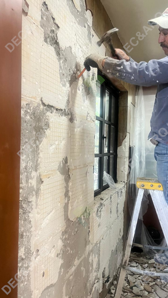 Hombre con herramienta retira mosaicos de la pared
